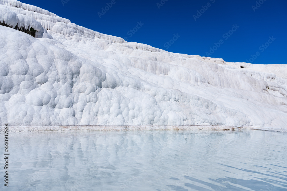 钙华景观。土耳其帕穆卡莱。露台上的蓝色海水。旅游胜地