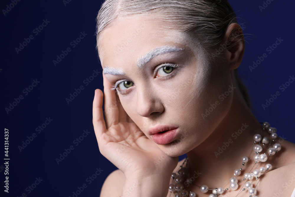 Beautiful young woman with dyed eyebrows and necklace on color background