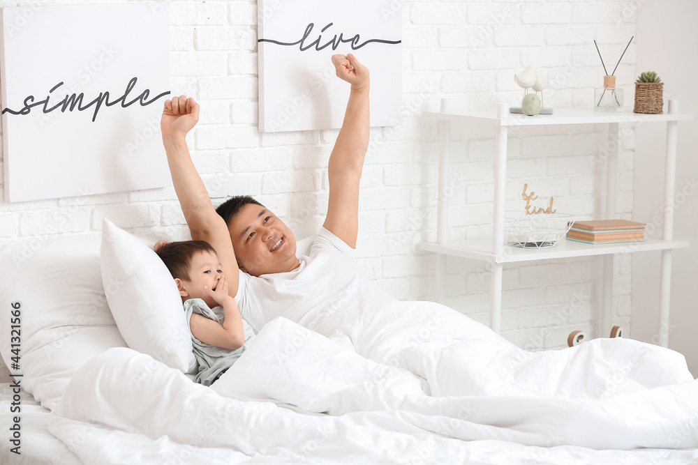 Morning of father and his little son in bedroom