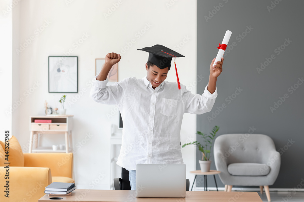 Happy African-American student on his graduation day at home. Concept of online education