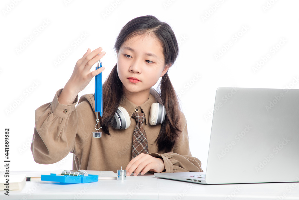 Little Asian girl receiving online education on white background