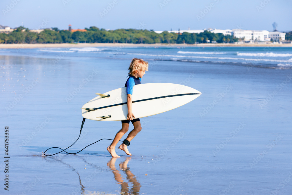 年轻的冲浪者在海浪上跑上冲浪板