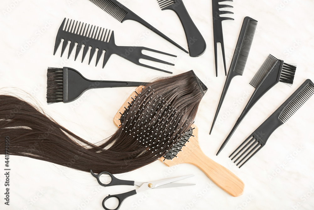 Barber set with strand of brunette hair on white background