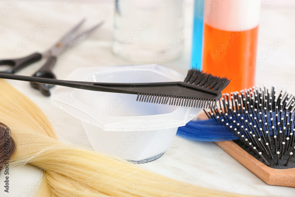 Barber set with strands of blonde hair on table, closeup