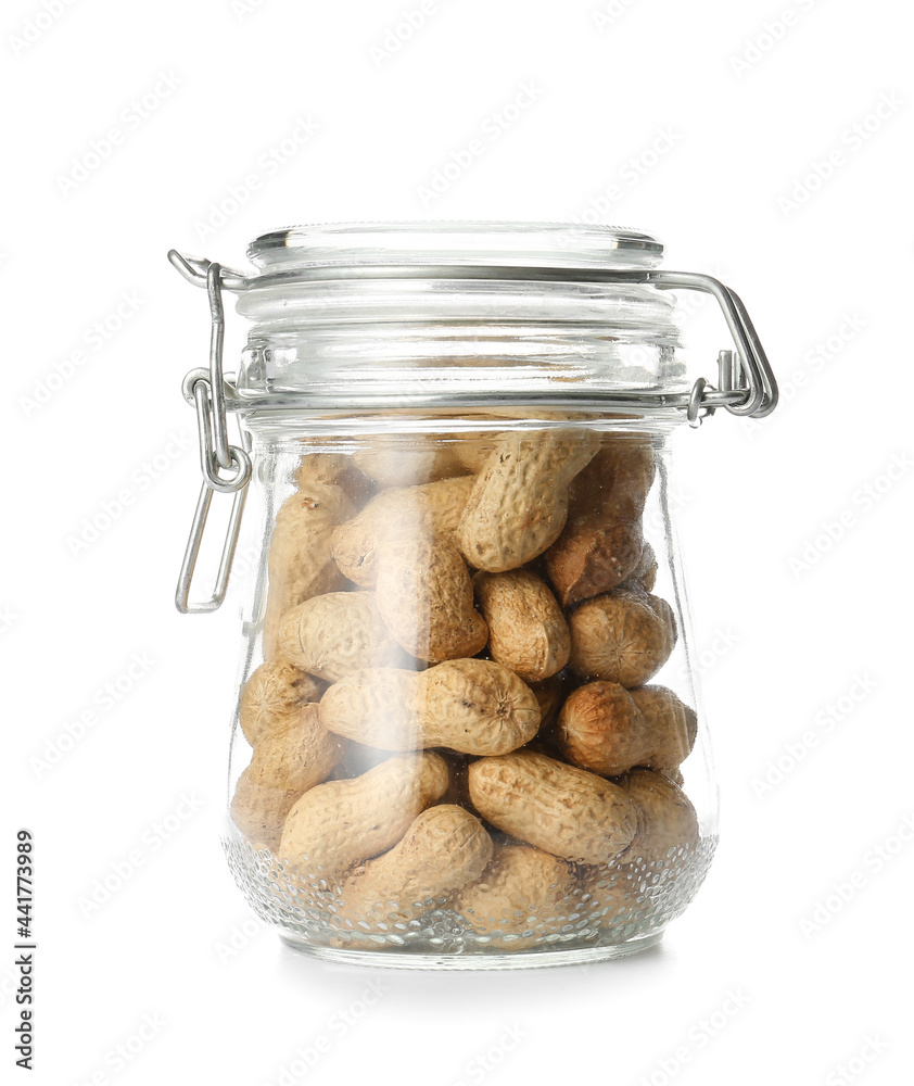 Glass jar with peanuts on white background