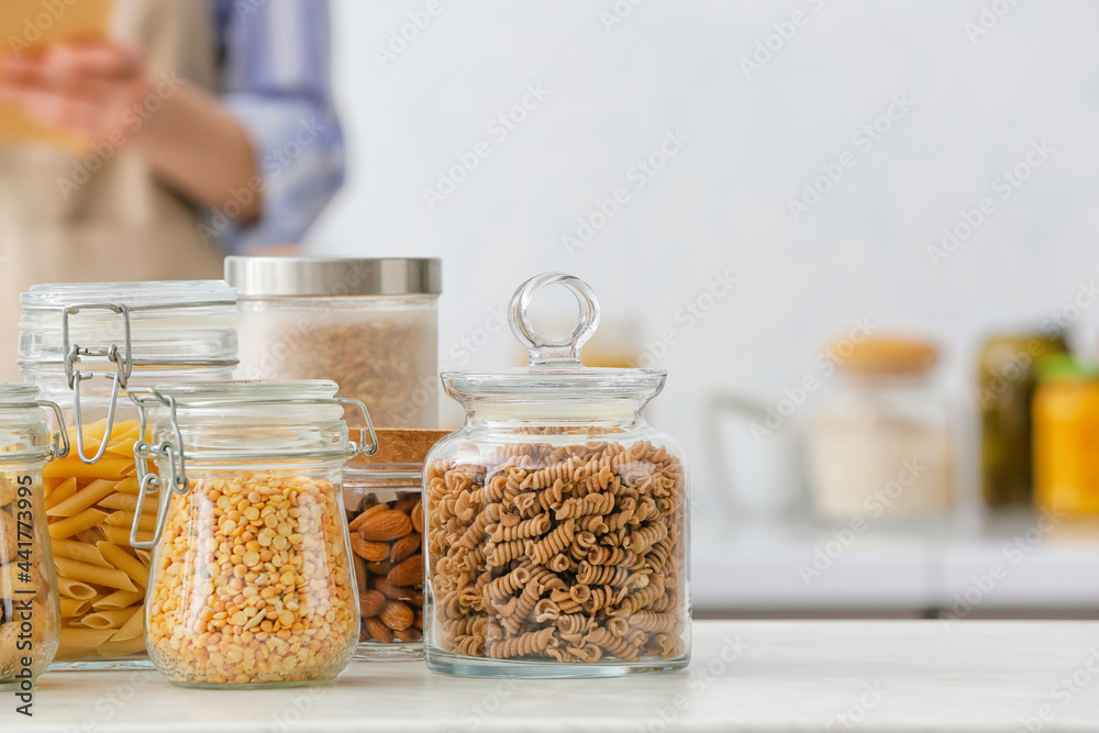 Jars with different products on table in kitchen