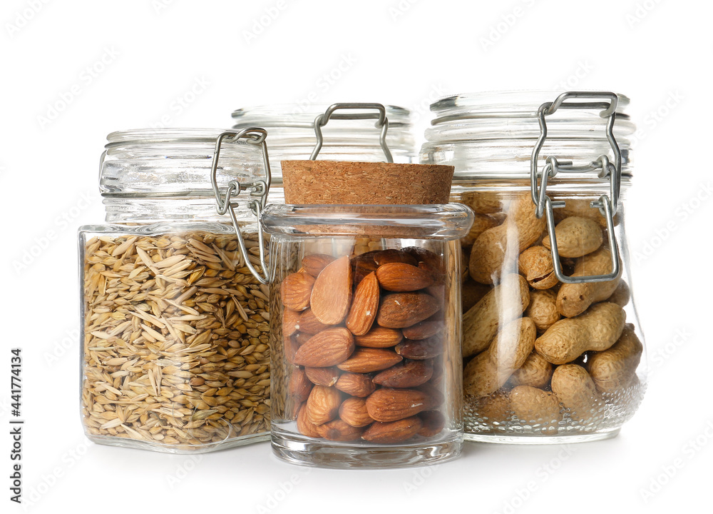 Glass jars with different products on white background