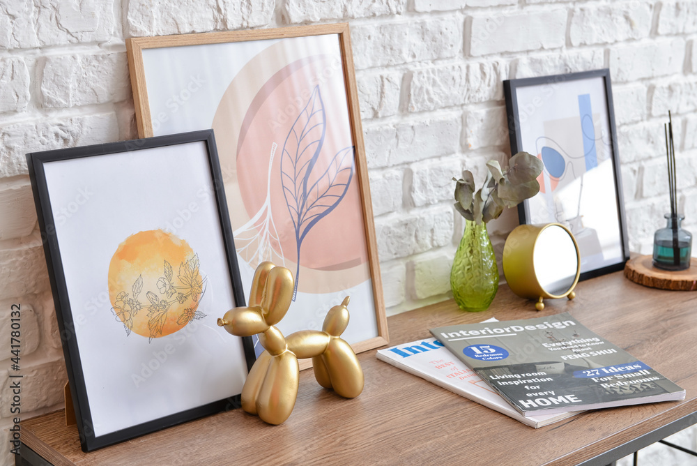 Table with pictures and decor near brick wall