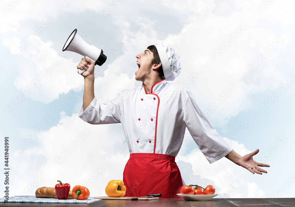 Young chef shouting loudly into megaphone