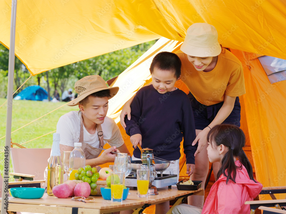 A happy family of four having a picnic outdoors