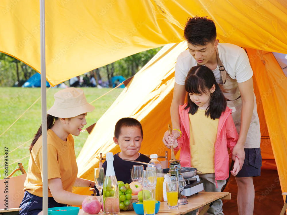 A happy family of four having a picnic outdoors