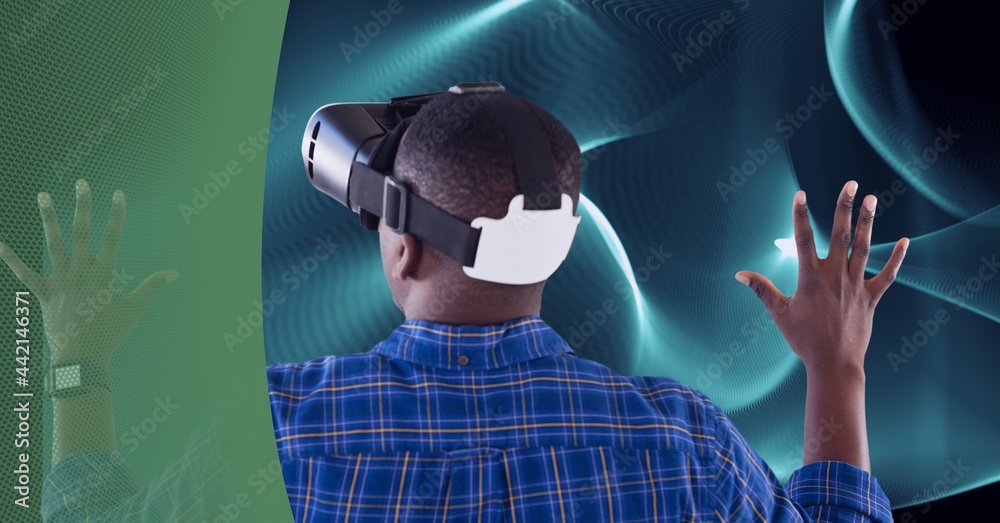 Composition of blue light trails and man wearing vr headset touching virtual screen