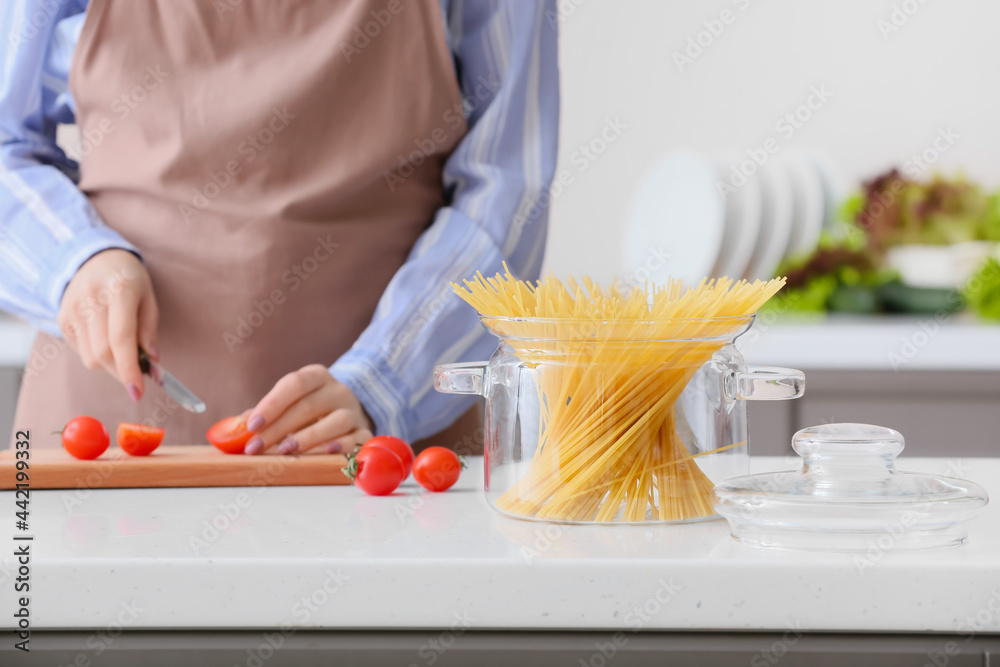 Woman cooking pasta in kitchen