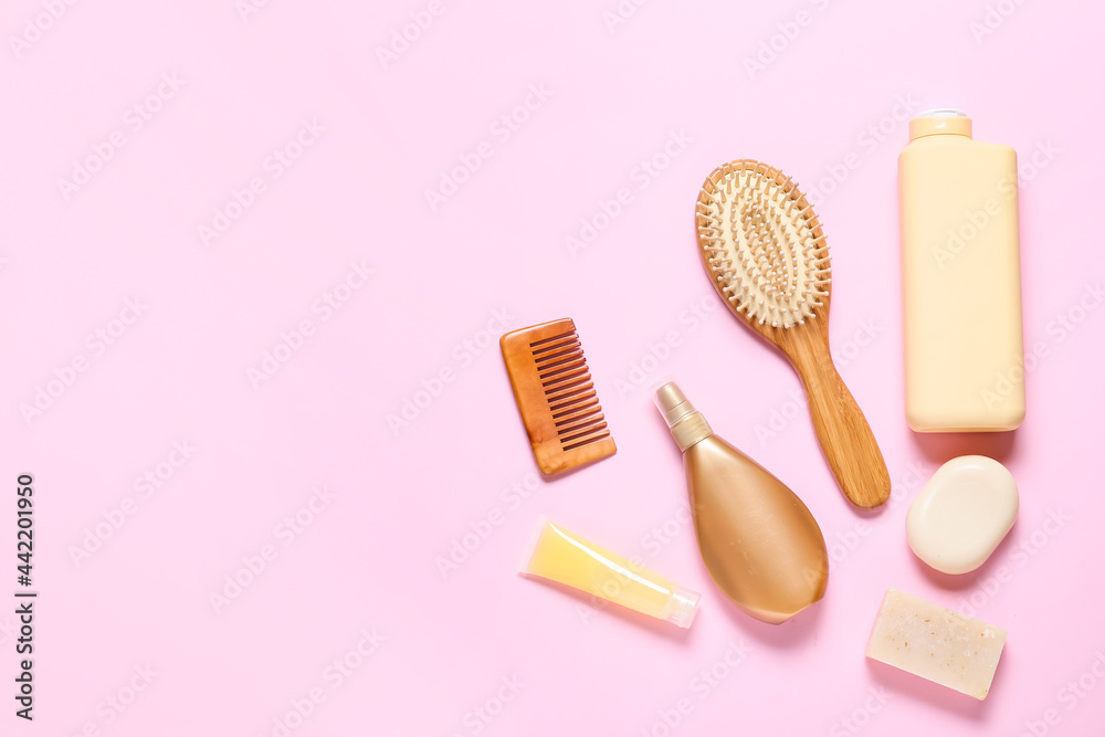 Hair brush, comb and cosmetics on color background