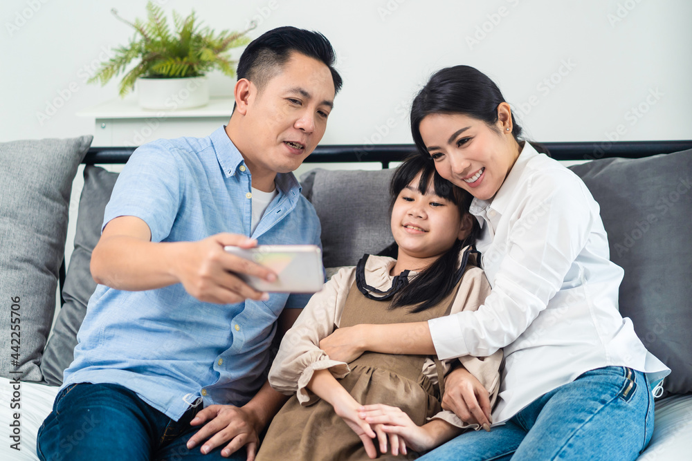 Asian Parents and little kid use telephone video call online to family