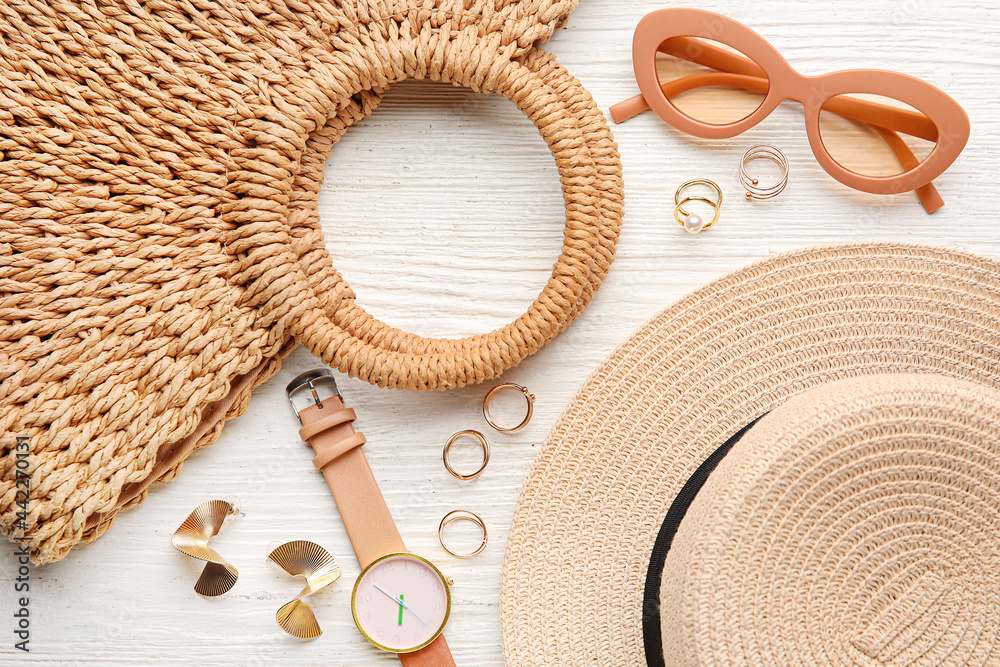 Set of female accessories with stylish hat on light wooden background