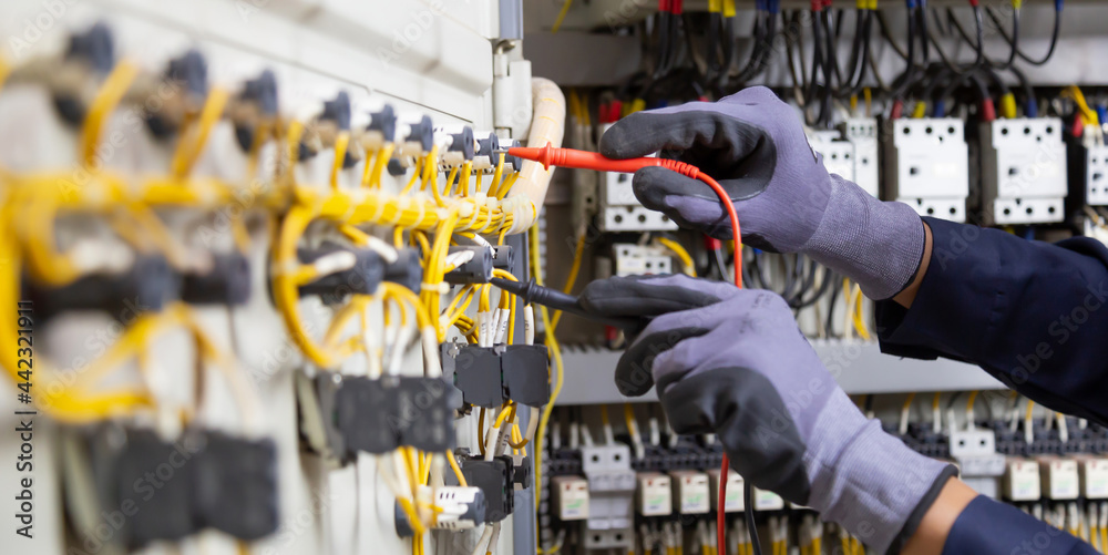 Electrician engineer tests electrical installations and wires on relay protection system. Adjustment