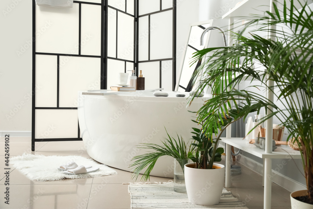 Interior of stylish bathroom with folding screen