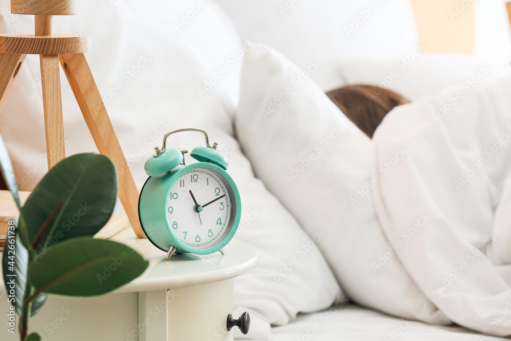 Alarm clock on table of young woman in morning