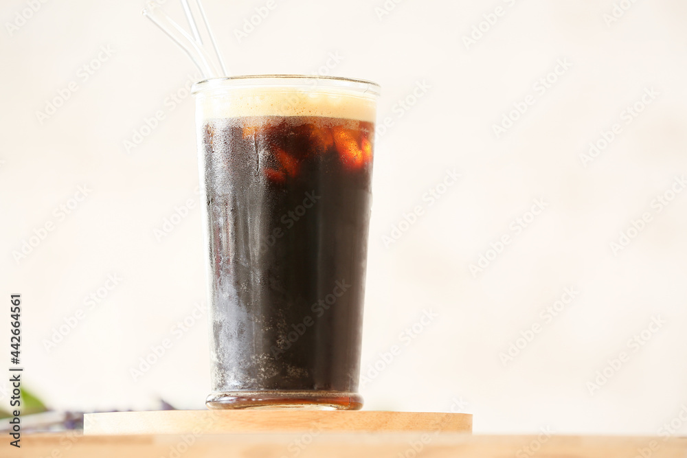 Glass of tasty iced coffee on table