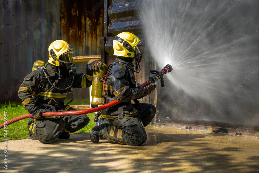 Firefighters are conducting fire drills by spraying water to extinguish the raging fire.