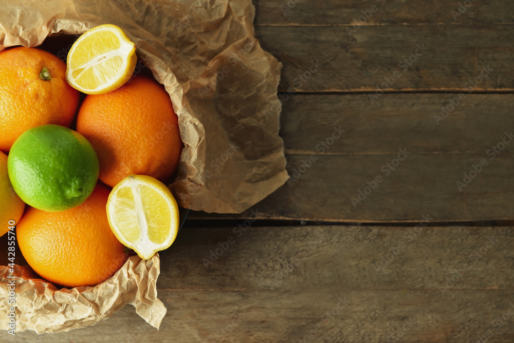 Bowl with healthy citrus fruits on wooden background