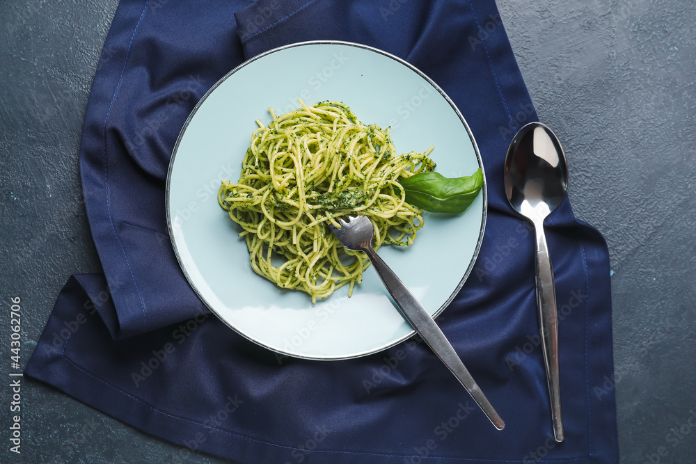 Plate with tasty pesto pasta on dark background