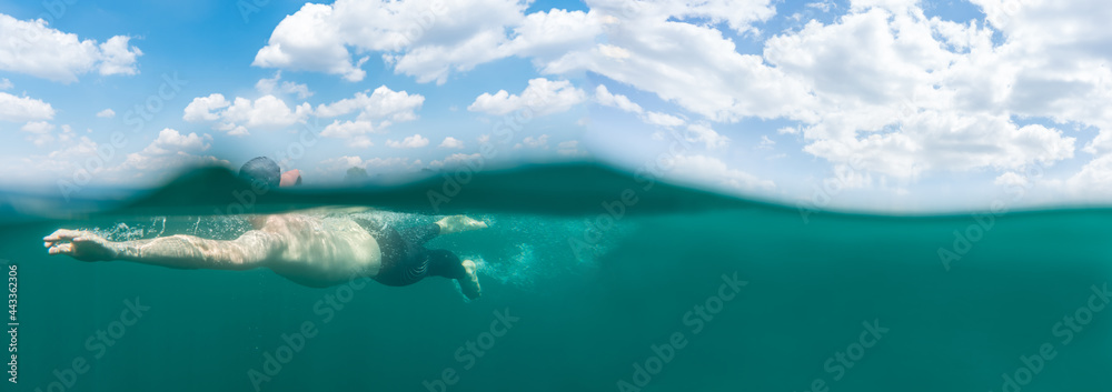 Man swimming in blue water, open water swimming