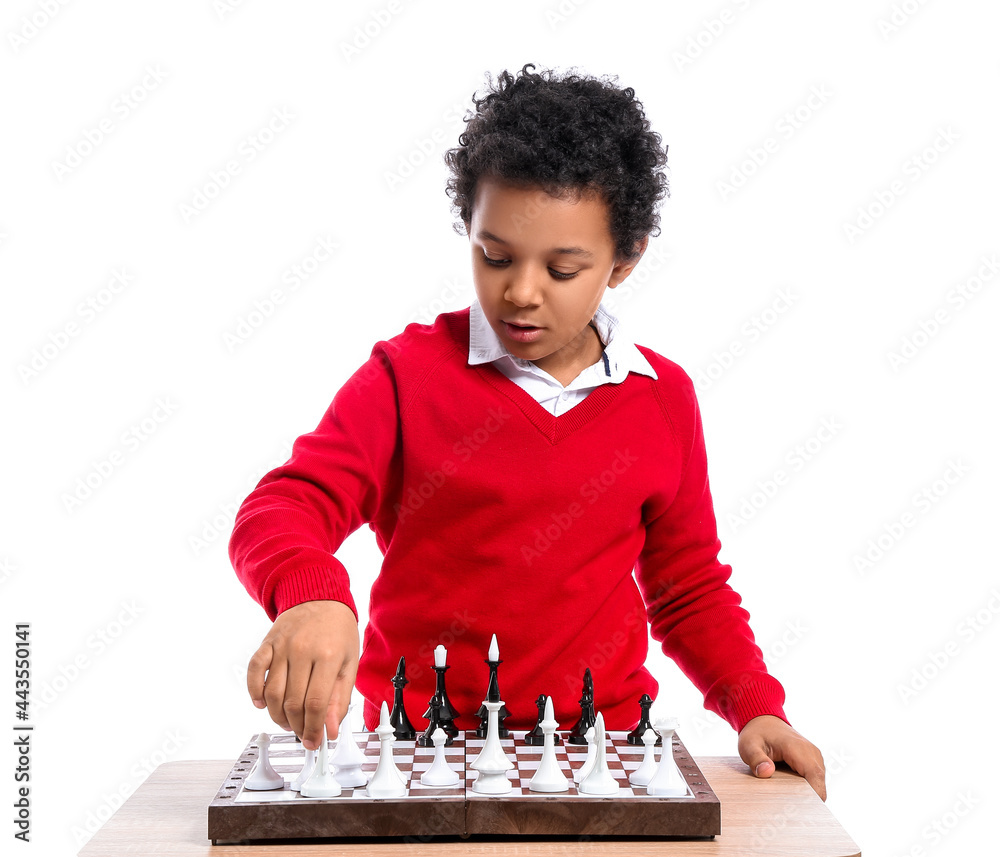 Cute African-American boy playing chess on white background