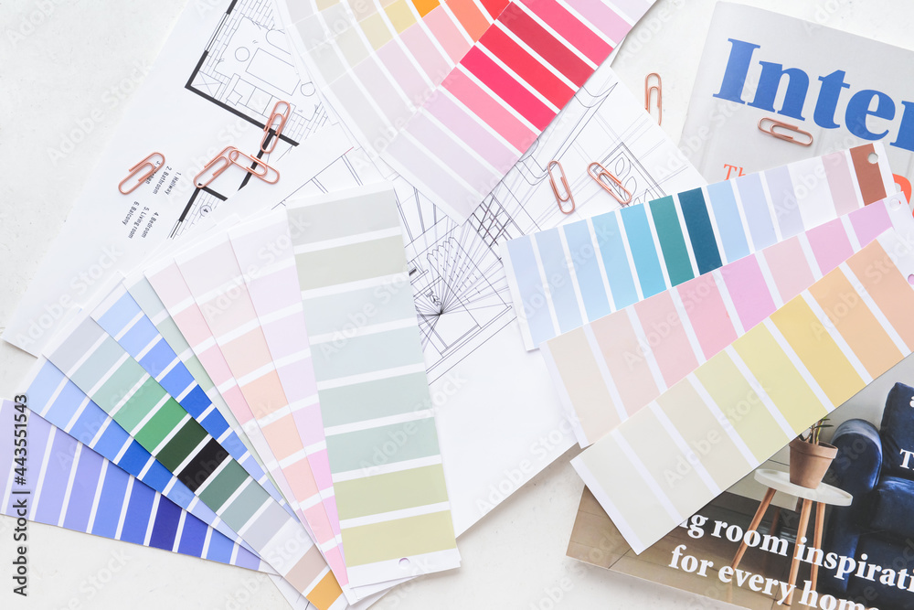 Paint color samples with house plan and magazine on white background