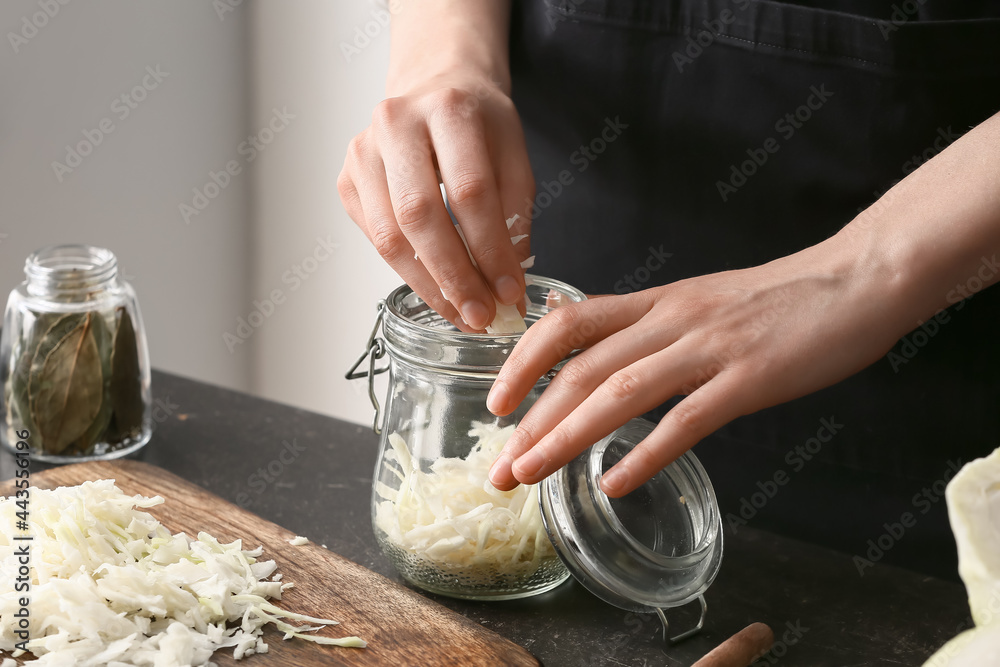 女人在厨房餐桌上准备美味的酸菜，特写镜头