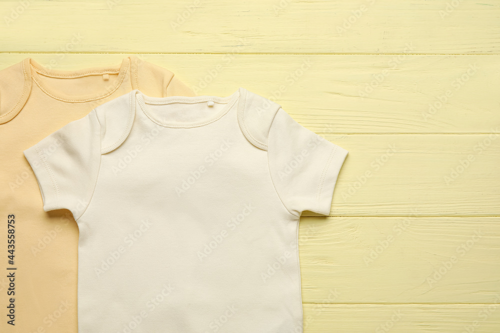 Baby clothes on color wooden background