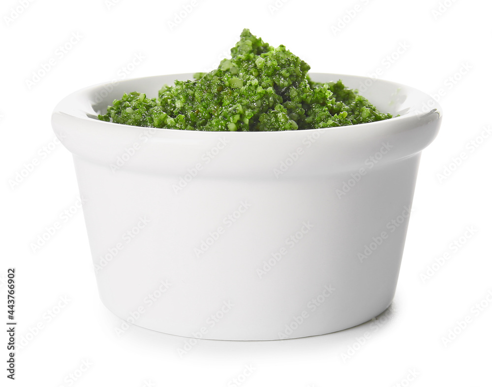 Bowl with fresh pesto sauce on white background