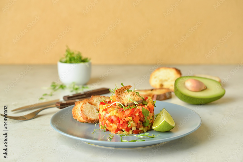 Plate with tasty tartare salad on table