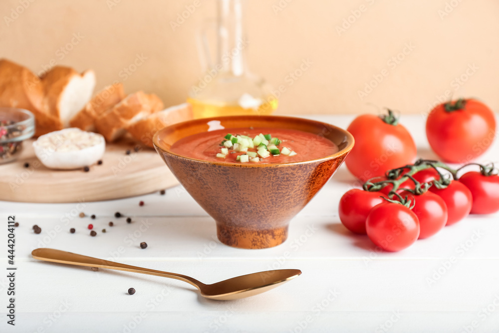 Bowl with tasty gazpacho on light wooden background