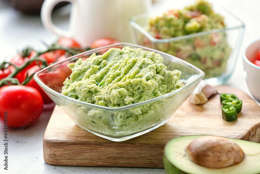 Bowl with tasty guacamole on table, closeup