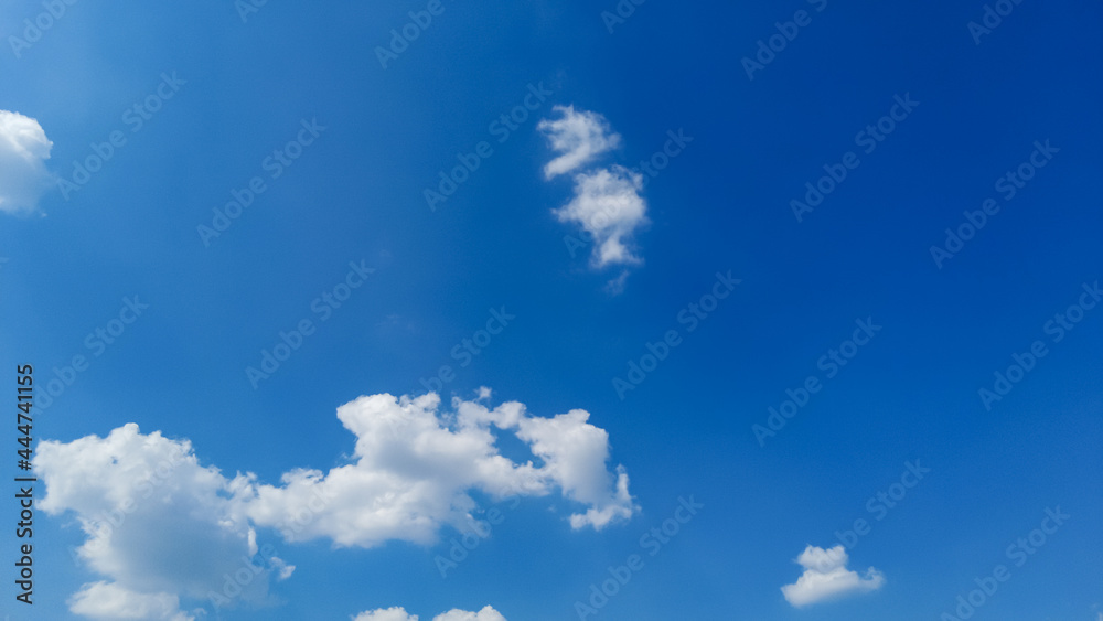 White cumulus clouds in the sky on a sunny summer day.