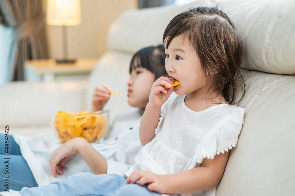 亚洲饥饿的小女孩兄弟姐妹用手把零食放进嘴里