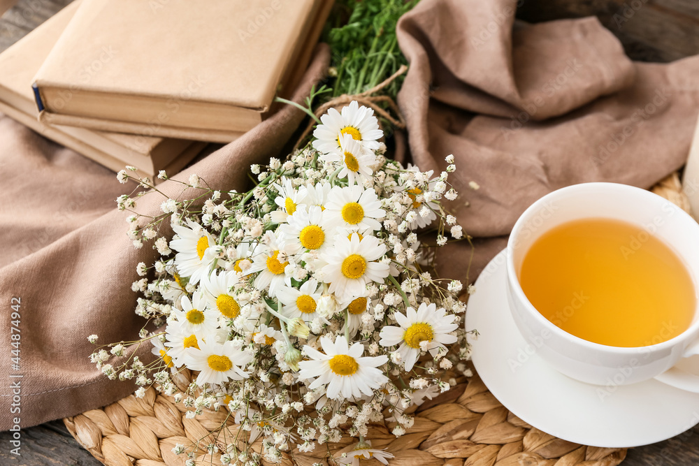 桌上有美丽的洋甘菊花、一杯茶和书的作文