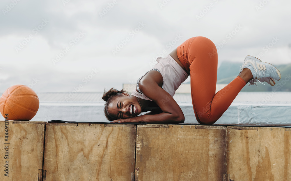 Sporty woman laughing during workout session on rooftop