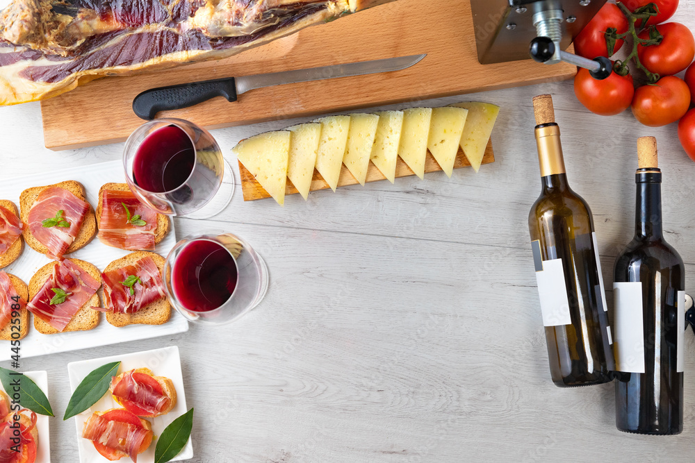 Spanish tapas and appetizers.Tapas and appetizers of Iberian ham with a glass of wine, ripe tomatoes