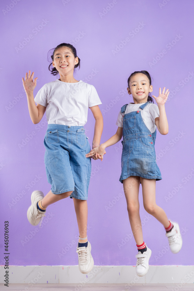 Portrait of two Asian girls on purple background