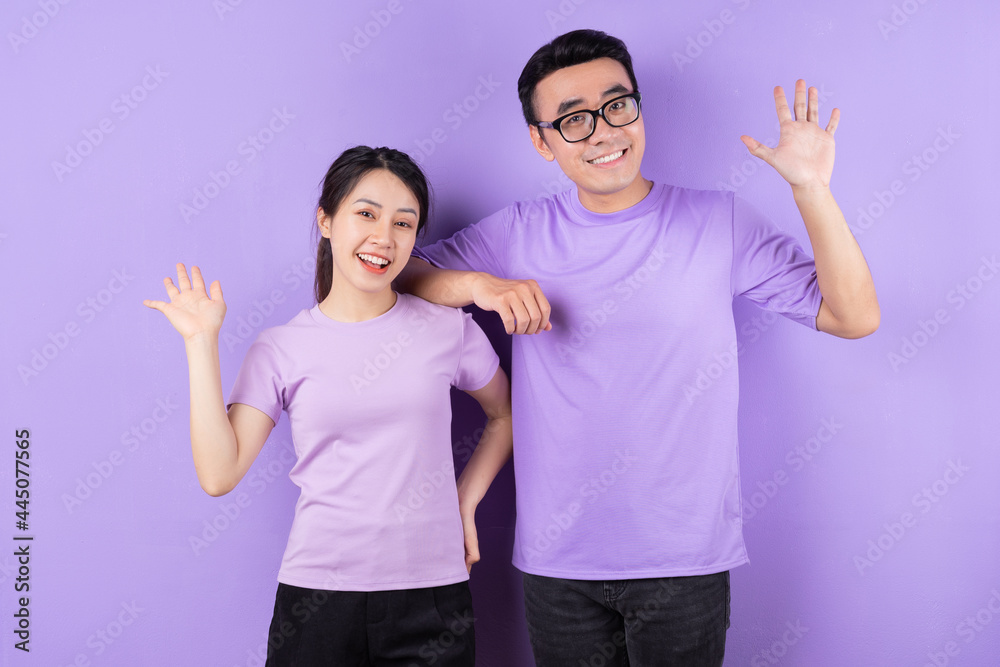 Young Asian couple posing on purple background