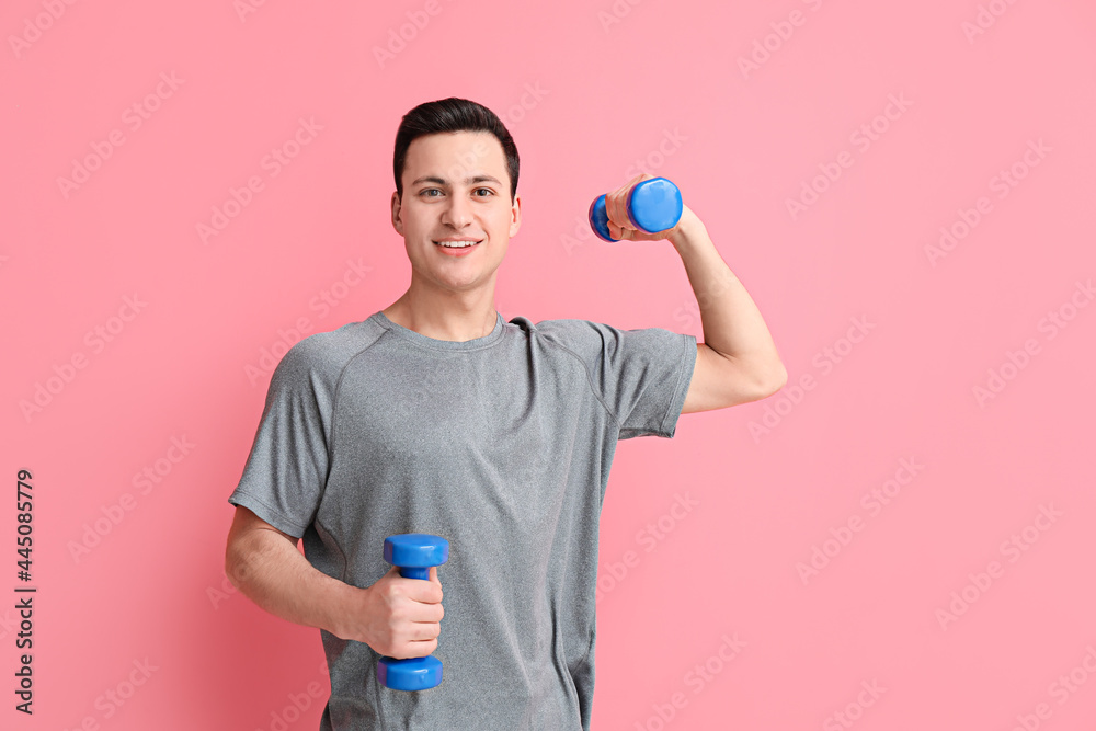 Sporty male coach with dumbbells on color background