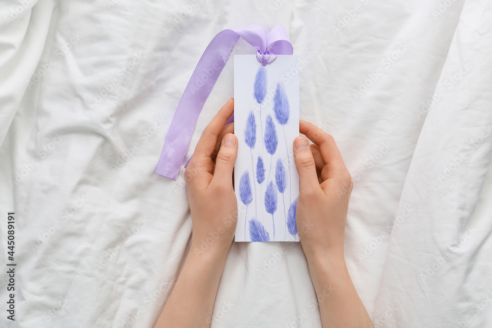 Woman with bookmark on bed