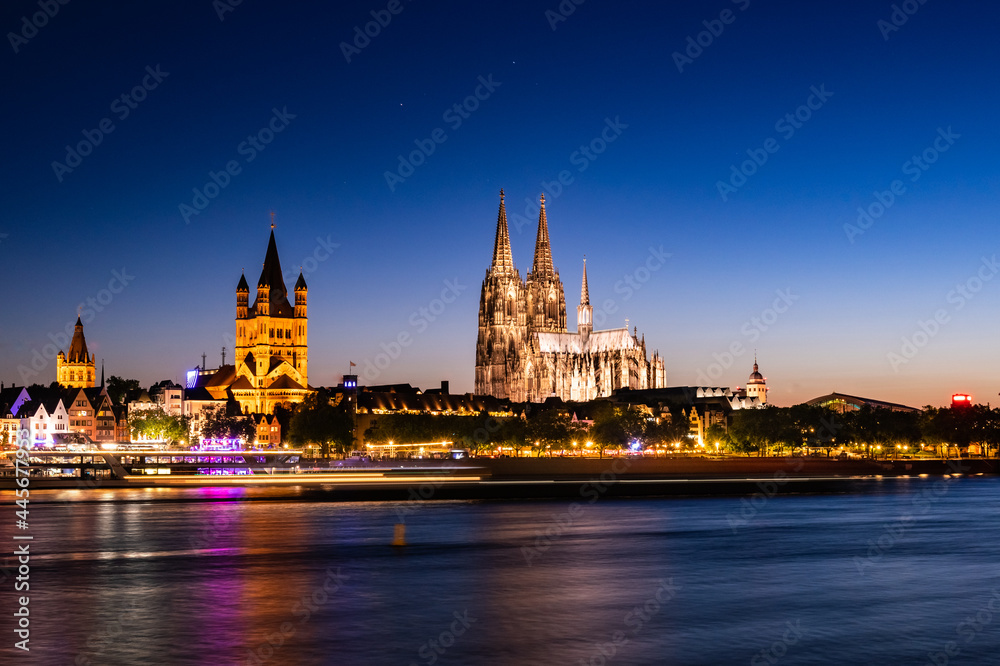 In Cologne, Germany, bright lit at night, the old buildings stand in the center of the city. Long sh