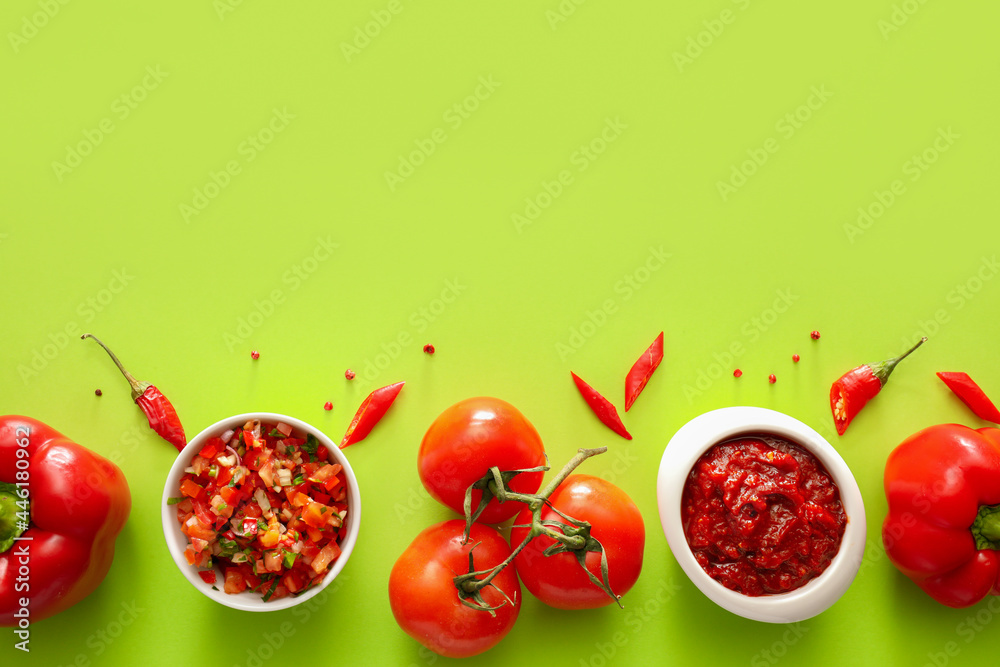 Bowls of tasty salsa sauces with ingredients on color background