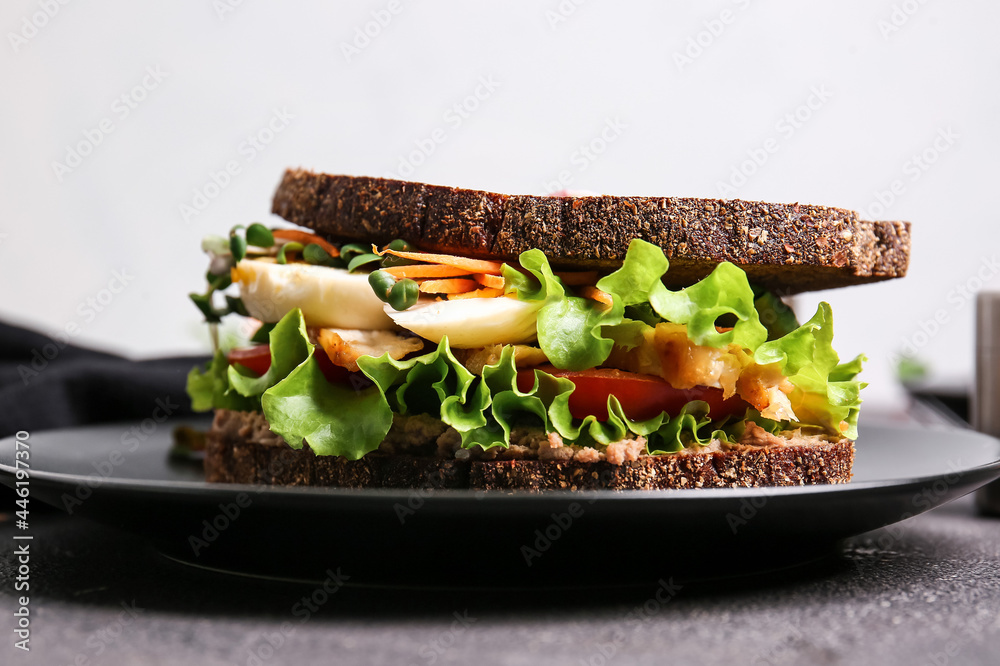 Plate with tasty sandwich on dark table, closeup