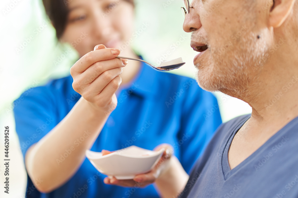 高齢者に食事の介助をする介護士