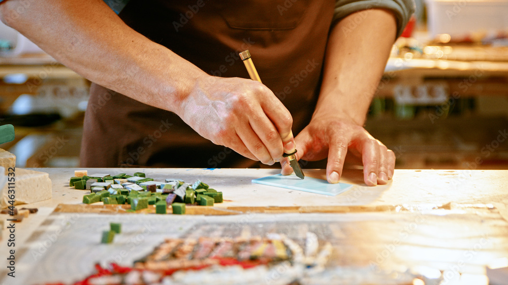 Male hands cutting a piece of glass in creative studio